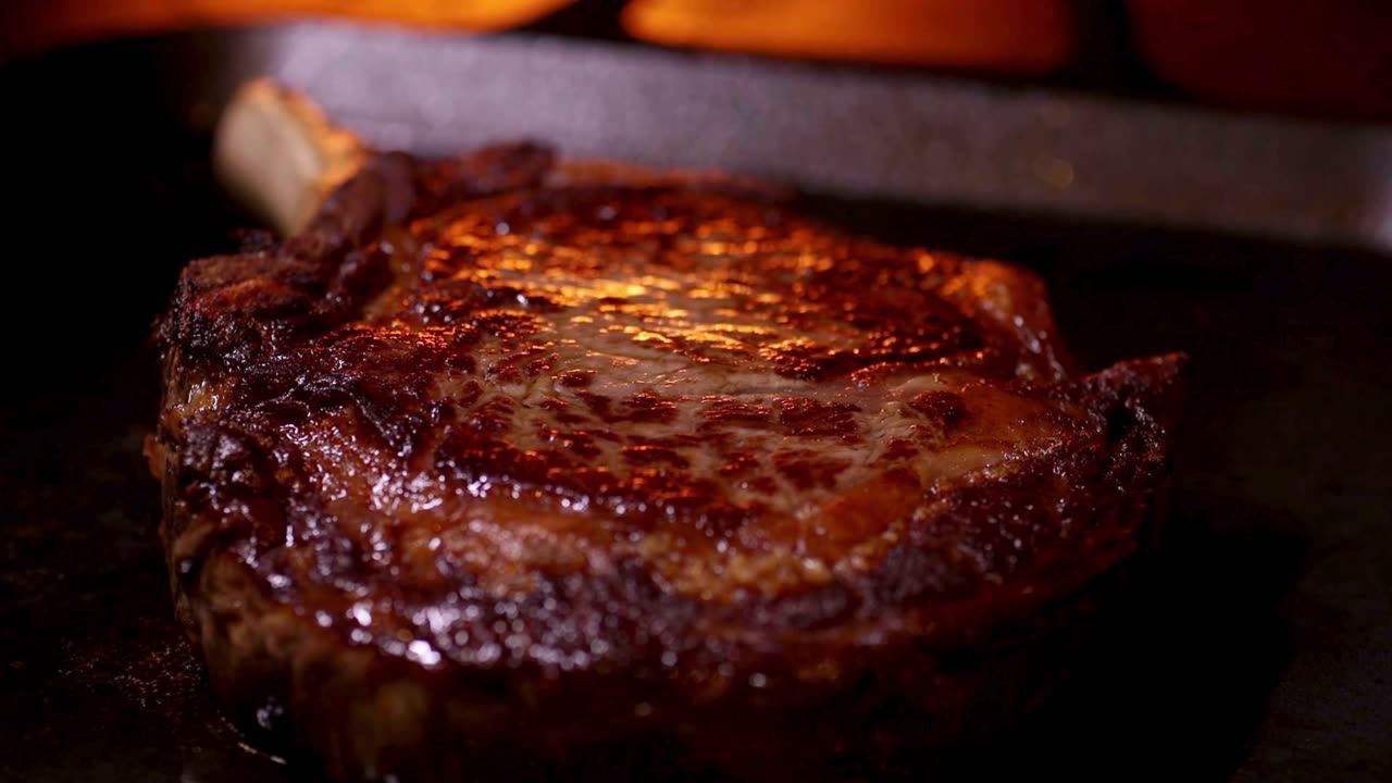 Marmoriertes Steak mit Rippenknochen auf dem heißen Grill